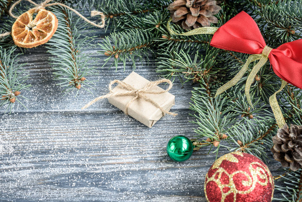 Різдвяний або новорічний прикраси фон з ялиновими гілками, шишками, кульками, зефіром на сірій дерев'яній дошці
. - Фото, зображення
