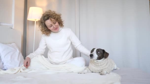 A nő és a kutyája pihennek reggel az ágyban. - Felvétel, videó