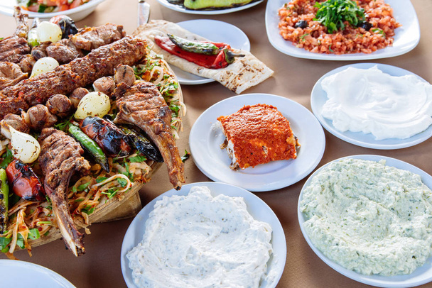 Traditional Turkish Adana Kebab with salads, appetizers, raki and salgam. Turkish Cuisine Dining Dinner Table in Turkish Restaurant. This is Turkish food culture in Turkish Restaurant. - Photo, Image