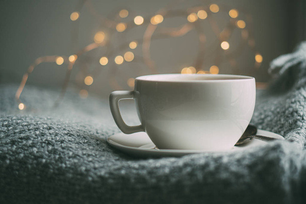 Cup of coffee with milk on cozy knitted winter blanket - Fotó, kép