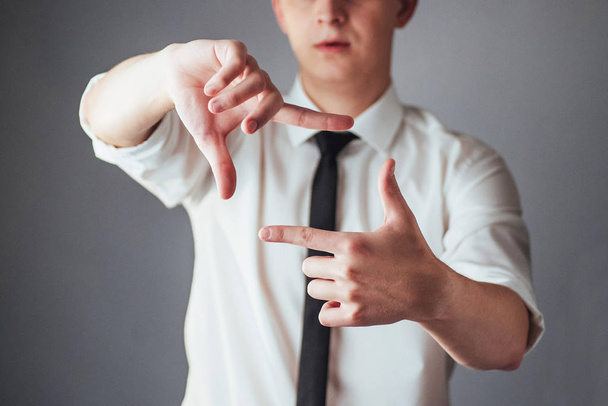 Young businessman showing empty hands, ready to fill with your design. - Foto, Imagen