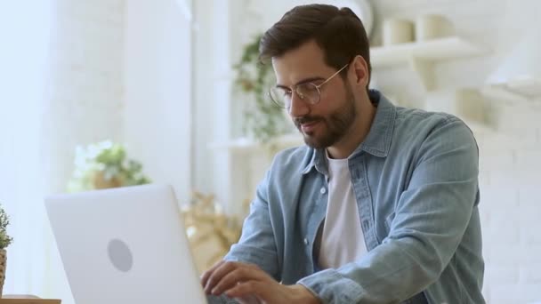 Young man freelancer using laptop studying working online at home - Video, Çekim