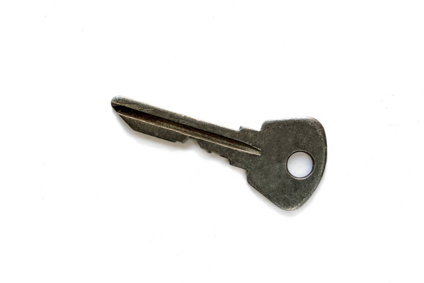 key with traces of aged metal on a white background with shadow. isolated object. concept of wealth, business, real estate - 写真・画像
