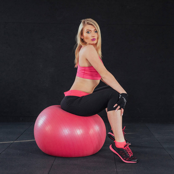 Young attractive slim woman in sportswear, doing fitness exercise ball - Fotografie, Obrázek
