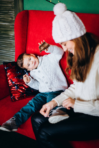 Woman and small boy having fun sitting on red sofa - Photo, image