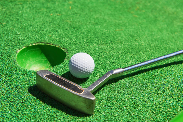 Μπάλα του γκολφ και γκολφ κλαμπ στην τεχνητή χόρτο. - Φωτογραφία, εικόνα