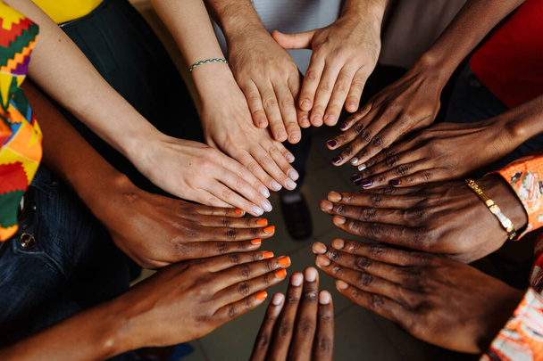 Χέρια ευτυχούς ομάδας πολυεθνικών Αφρικανών, Λατινοαμερικανών και Ευρωπαίων που μένουν μαζί σε κύκλο - Φωτογραφία, εικόνα