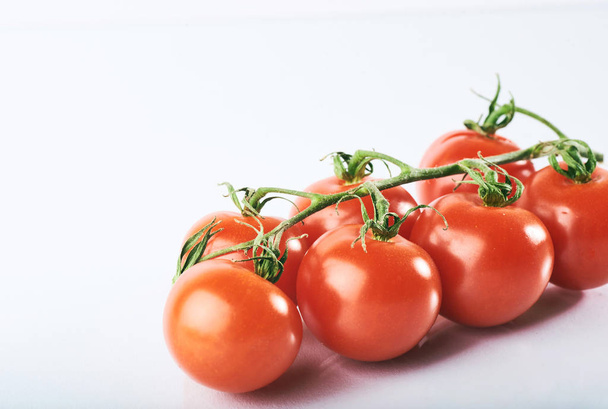 Branch of red organic tomatoes on a white background. - Valokuva, kuva