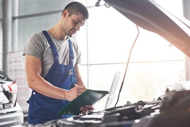 Picture showing muscular car service worker repairing vehicle. - Foto, afbeelding