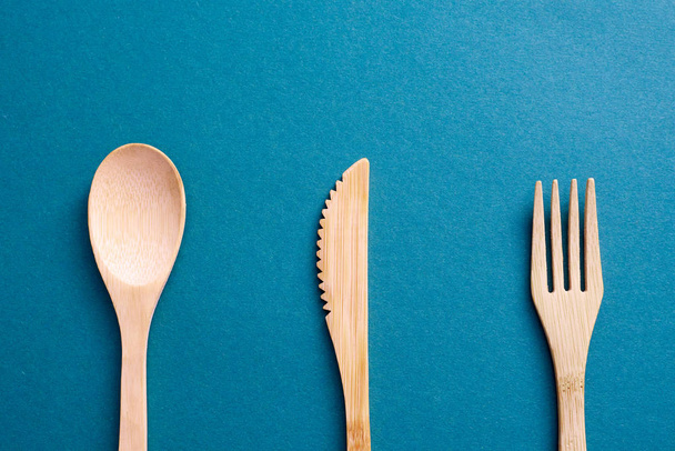 Wooden utensils on calm blue paper background - Photo, Image