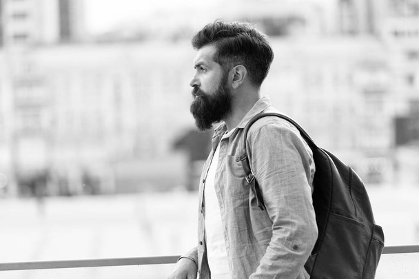 Looking for adventures. Tourist handsome thoughtful hipster backpack. Man with beard and rucksack explore city. Travelling concept. Tourist on vacation. Hipster modern tourist urban background - Фото, изображение