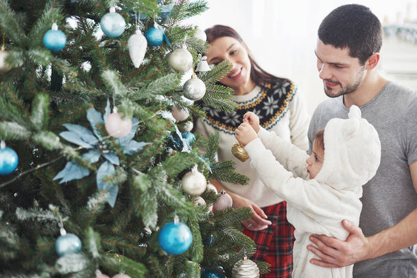 Happy Family Decorating Christmas Tree together. Father, Mother And Daughter. Cute Child - Fotoğraf, Görsel
