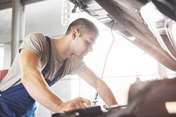 Auto mechanic working in garage. Repair service. - Photo, image