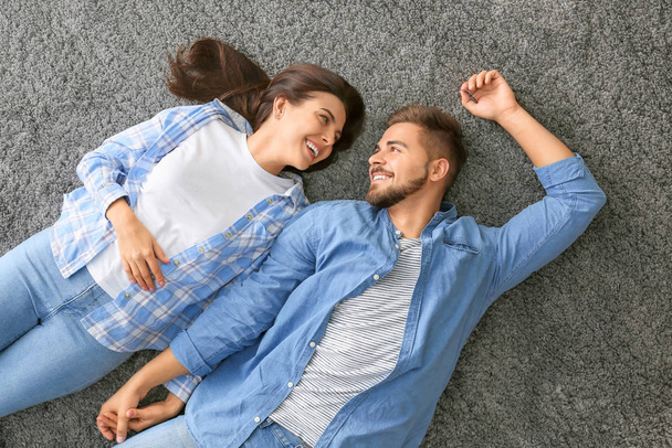 Portrait de beau jeune couple couché sur le sol, vue de dessus
 - Photo, image