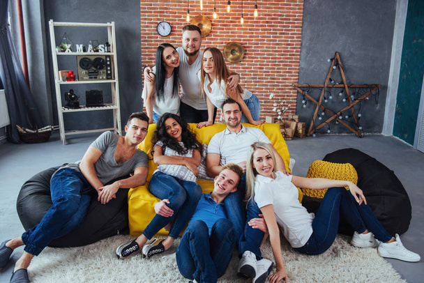 Group portrait of multi-ethnic boys and girls with colorful fashionable clothes holding friend and posing on a brick wall, Urban style people having fun, Concepts about youth and togetherness lifestyle. - Φωτογραφία, εικόνα