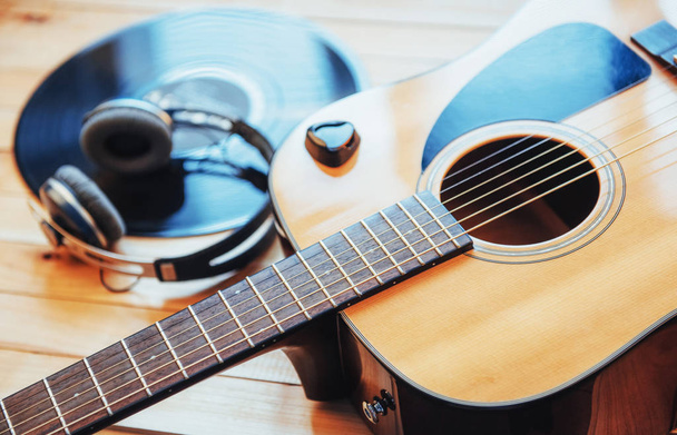 Classical guitar with headphones on a wooden background. - Foto, Imagem