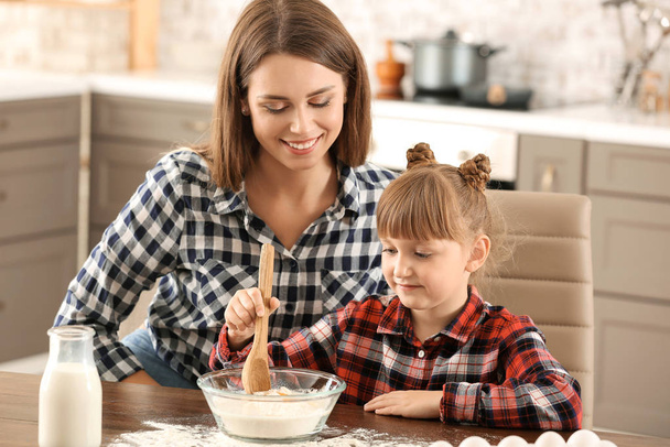 Mãe feliz e filha cozinhar pastelaria em casa
 - Foto, Imagem