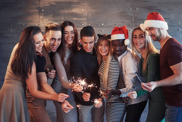 Party with friends. Group of cheerful young people carrying sparklers and champagne flutes. Concepts about youth togetherness lifestyle. - Fotoğraf, Görsel