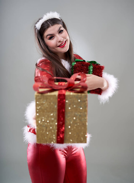 Beautiful young Santa girl with presents to give - 写真・画像