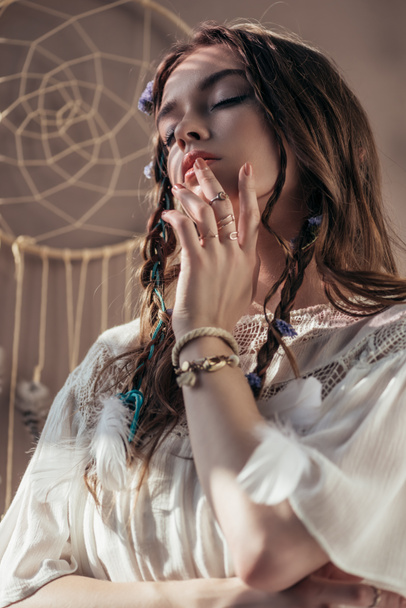 beautiful girl with braids in white boho dress on beige with dream catcher - 写真・画像