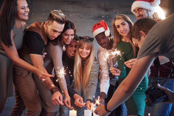 Party with friends. Group of cheerful young people carrying sparklers and champagne flutes. Concepts about youth togetherness lifestyle. - Fotó, kép