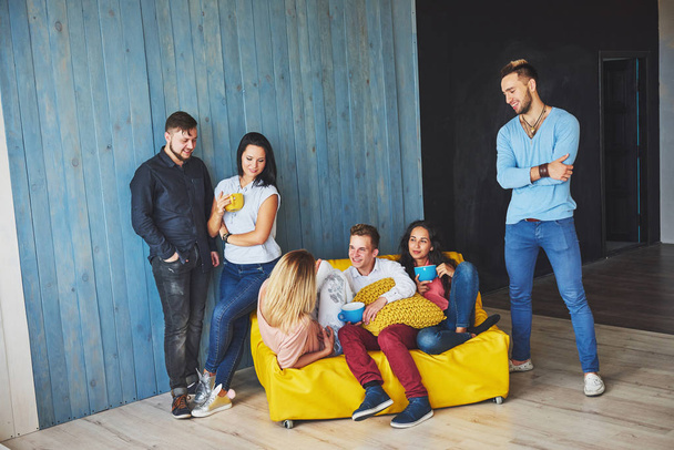 Group portrait of multi-ethnic boys and girls with colorful fashionable clothes holding friend and posing on a brick wall, Urban style people having fun, Concepts about youth and lifestyle. - Valokuva, kuva