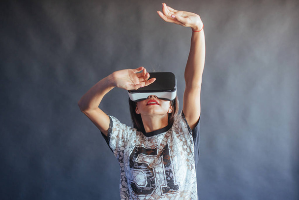 Happy woman gets experience of using VR-glasses virtual reality headset - Fotoğraf, Görsel