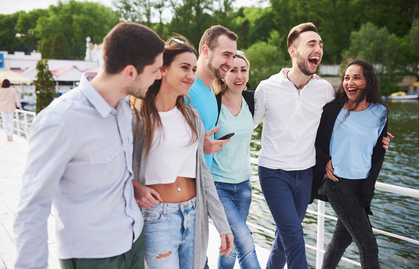 Group of smiling young and successful people on vacation on the dock. - 写真・画像