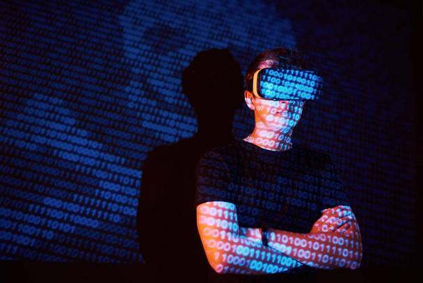 Double exposure of a caucasian man and Virtual reality VR headset is presumably a gamer or a hacker cracking the code into a secure network or server, with lines of code - Foto, Bild
