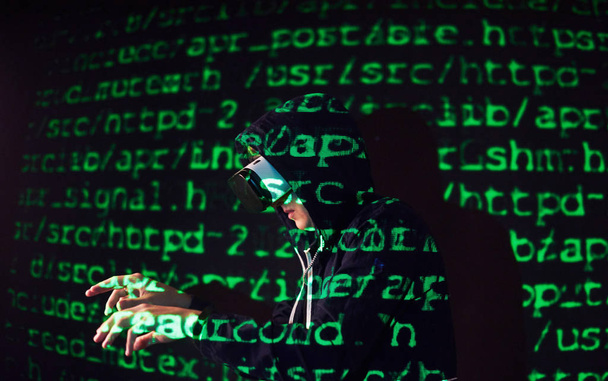 Double exposure of a caucasian man and Virtual reality VR headset is presumably a gamer or a hacker cracking the code into a secure network or server, with lines of code in green - Foto, immagini