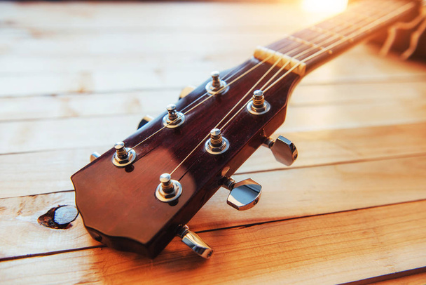 close up neck acoustic classical guitar on a light wooden background. - 写真・画像