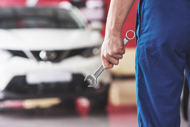 Hands of car mechanic with wrench in garage. - Photo, Image