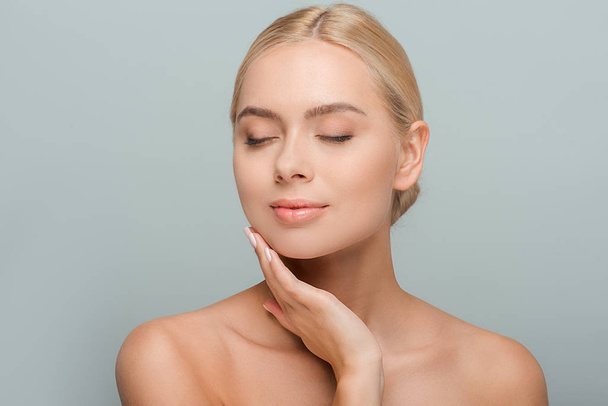 pretty woman touching clean face isolated on grey  - Photo, Image