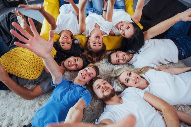 Groep mooie jonge mensen doen selfie liggend op de vloer, beste vrienden meisjes en jongens samen plezier hebben, poseren emotionele levensstijl mensen concept. - Foto, afbeelding