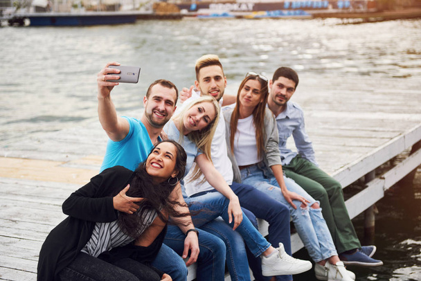 Groupe de beaux jeunes gens qui font Selfies couché sur la jetée, les meilleurs amis des filles et des garçons avec le concept de plaisir crée la vie émotionnelle des gens
 - Photo, image
