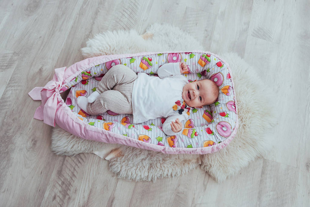 Photo charming newborn baby in a pink cradle. In good light studio - Photo, Image