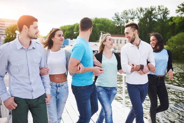 Group of smiling young and successful people on vacation on the dock. - Zdjęcie, obraz