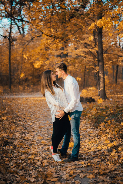 side view of beautiful happy young couple hugging in autumn park  - Valokuva, kuva