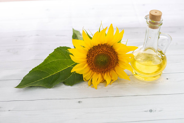 close-up view of beautiful yellow sunflower and bottle of sunflower oil  - Photo, image