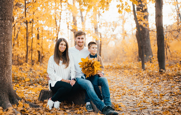 秋の森で一緒に過ごす小さな息子を持つ幸せな若い両親 - 写真・画像
