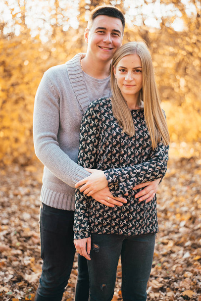 beautiful happy young couple hugging and smiling at camera in autumn park  - Foto, Bild