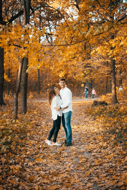 beautiful happy young couple standing together in autumn park - Foto, Imagem