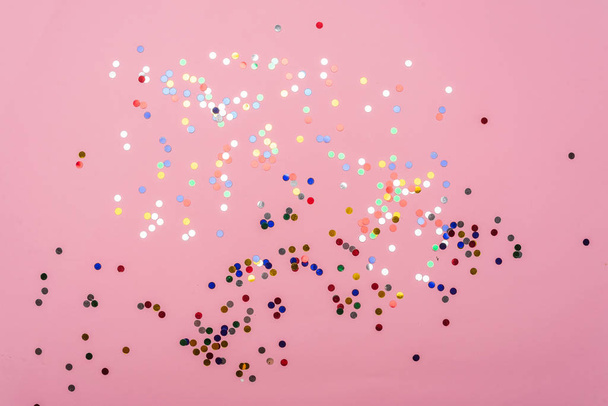 volledig frame weergave van feestelijke roze achtergrond met kleurrijke confetti - Foto, afbeelding