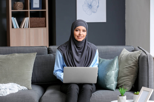 Belle étudiante musulmane avec ordinateur portable se préparant à l'examen à la maison
 - Photo, image