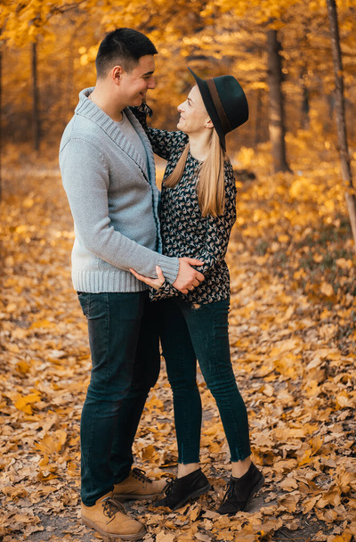 beautiful happy young couple hugging in autumn forest - Foto, Bild