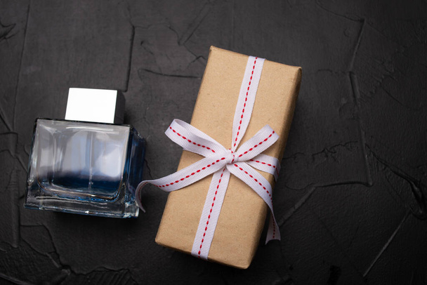 top view of gift box and bottle of perfume on black background - Valokuva, kuva