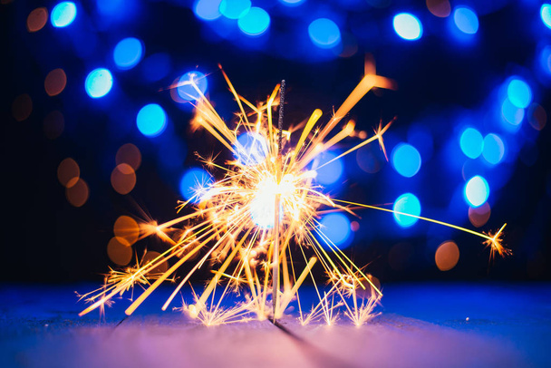 festive christmas background with burning sparkler  - 写真・画像