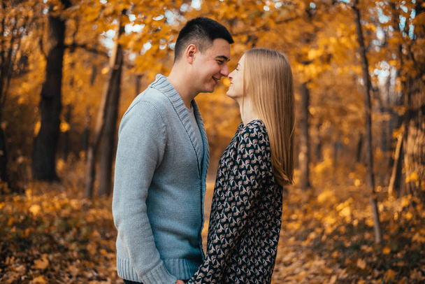 beautiful happy young couple kissing in autumn park - Fotó, kép