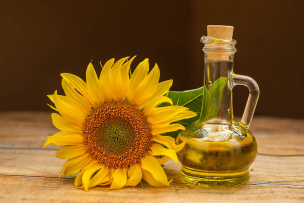 close-up view of beautiful yellow sunflower and bottle of sunflower oil  - Foto, imagen
