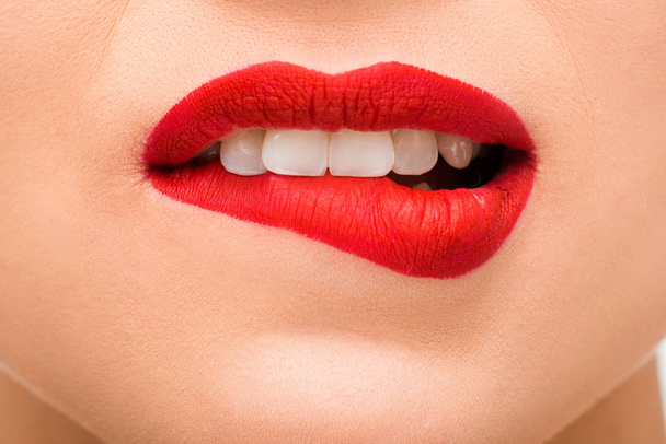 cropped view of sexy young woman with red lipstick biting lips  - Zdjęcie, obraz